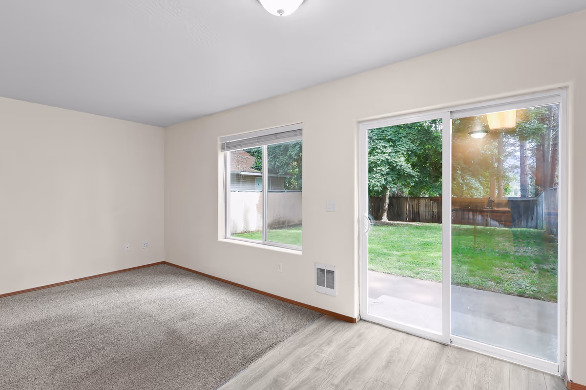 Living room opening to the backyard through sliding glass doors