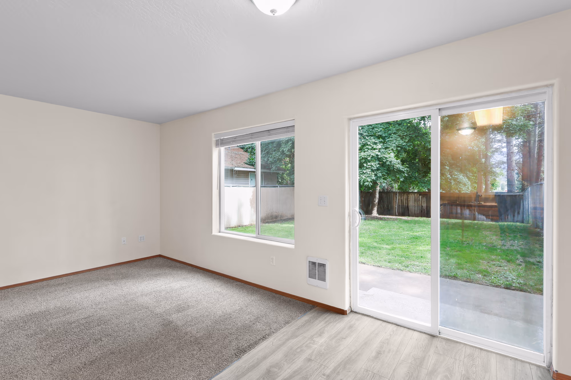 Living room opening to the backyard through sliding glass doors
