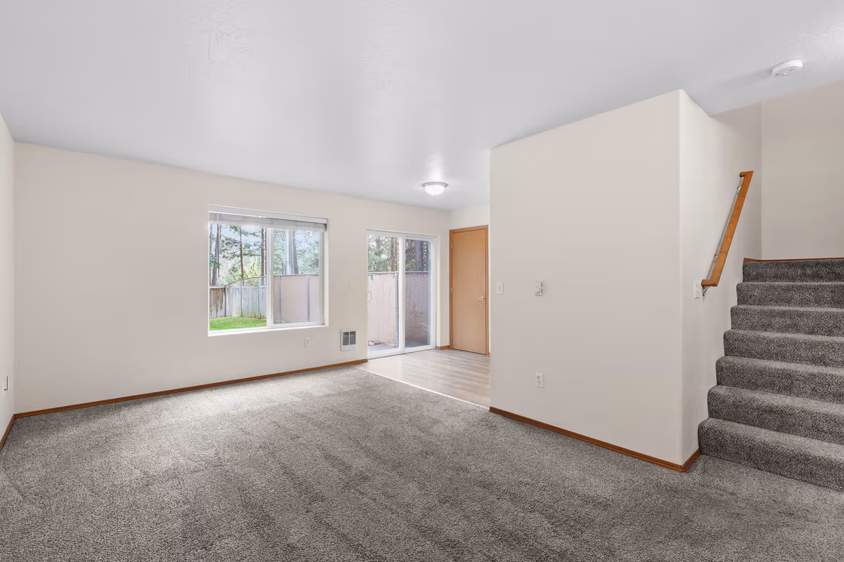Living room with a staircase and a large picture window