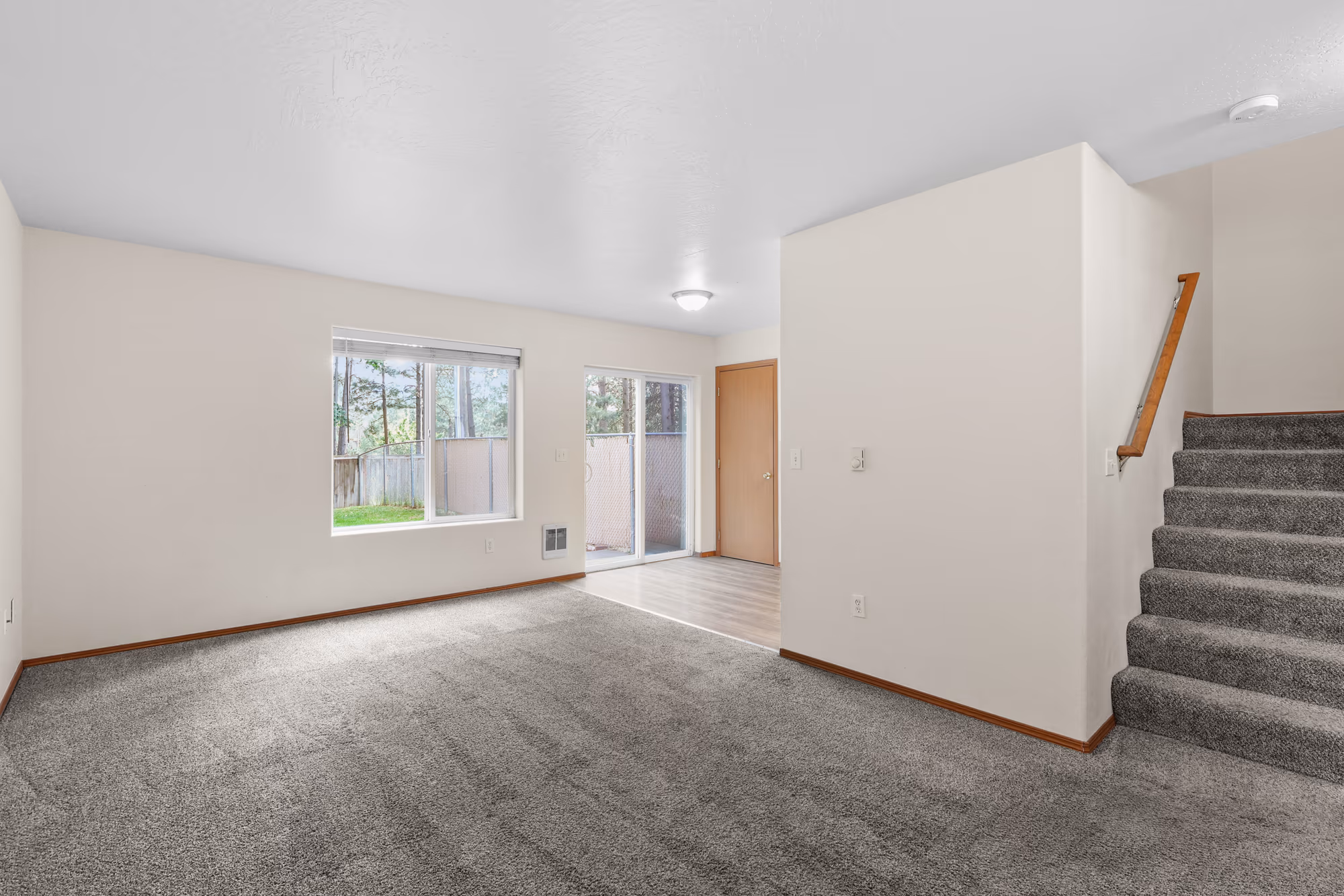 Living room with a staircase and a large picture window