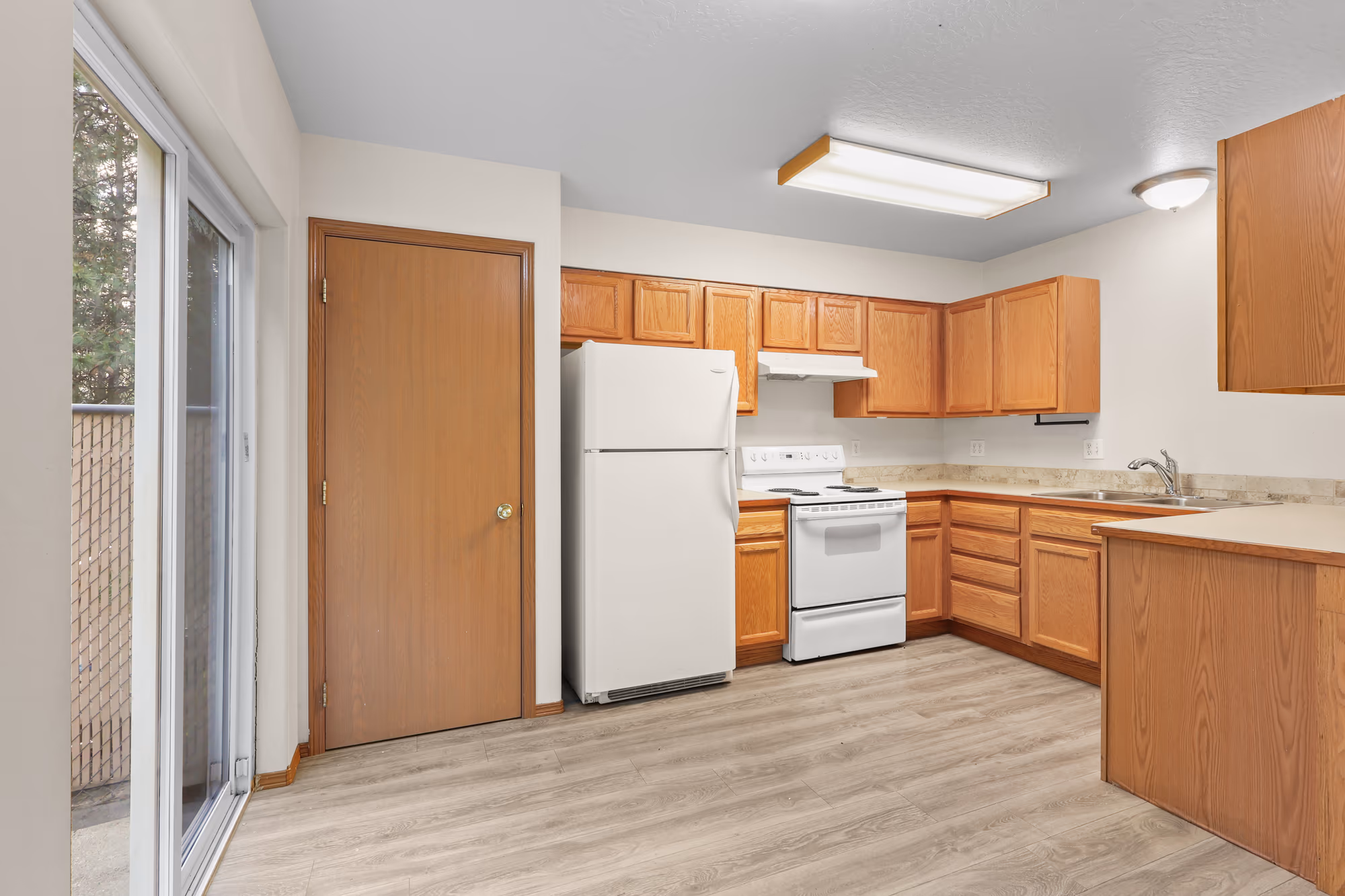 Kitchen with white appliances and a sliding patio door