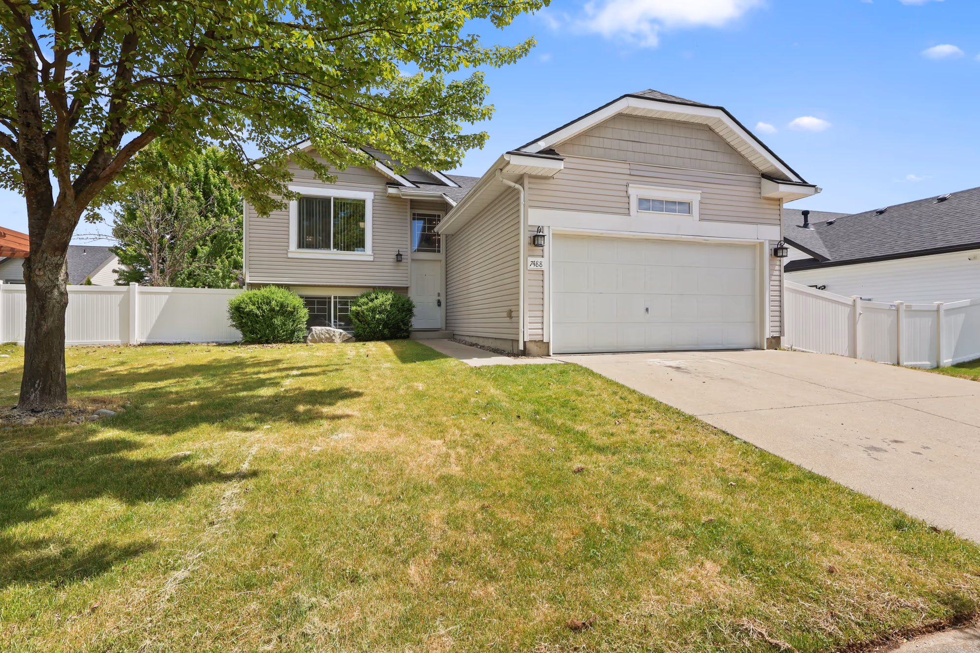 Two-story home exterior with attached garage and manicured lawn