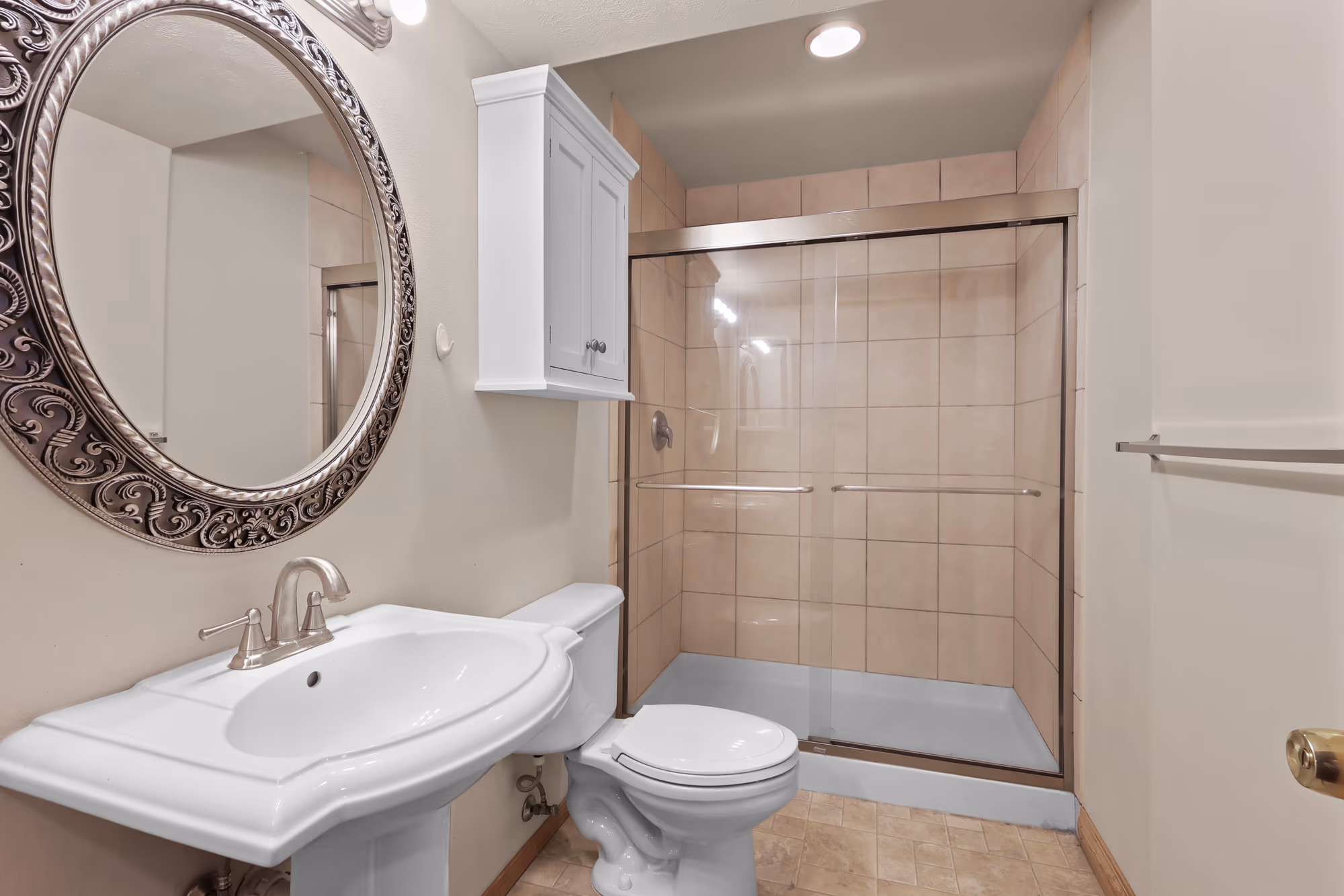 Bathroom with a round mirror and a glass walk-in shower