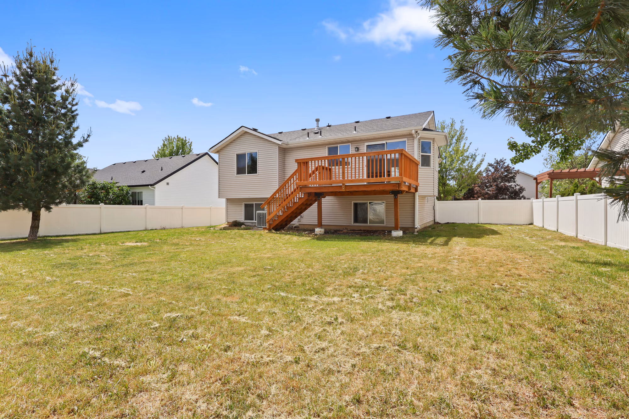 Backyard with a deck and a fenced lawn