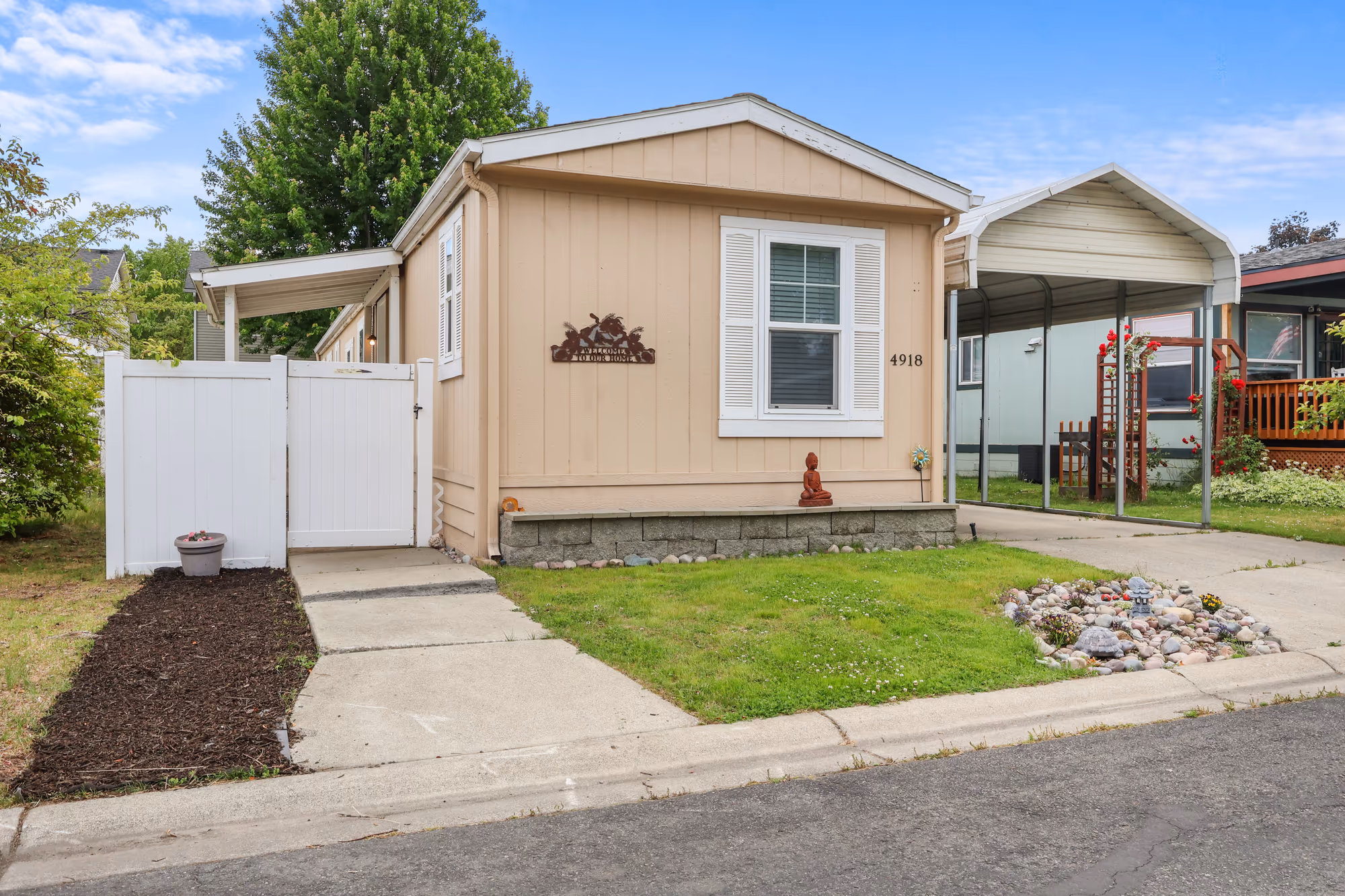 Single-level home exterior with a covered carport and tidy landscaping