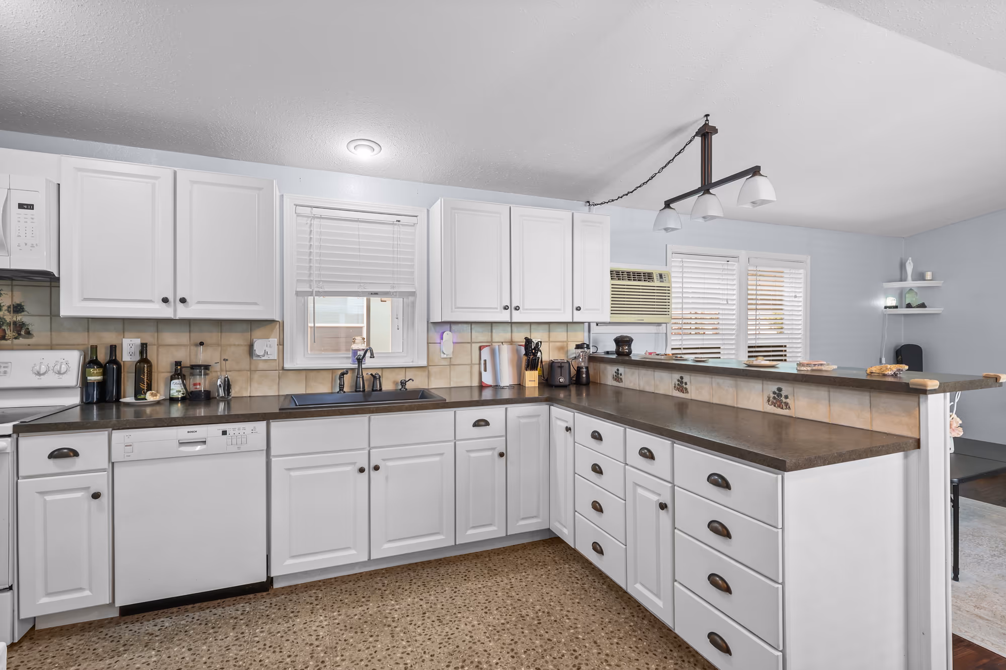 Kitchen with white cabinetry and a wraparound breakfast bar
