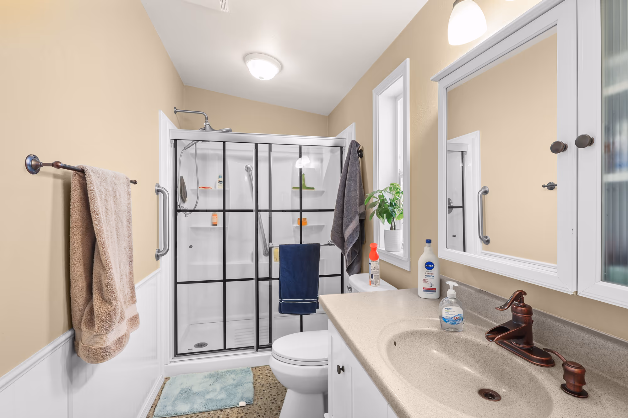 Bathroom with a black-framed glass shower and updated vanity