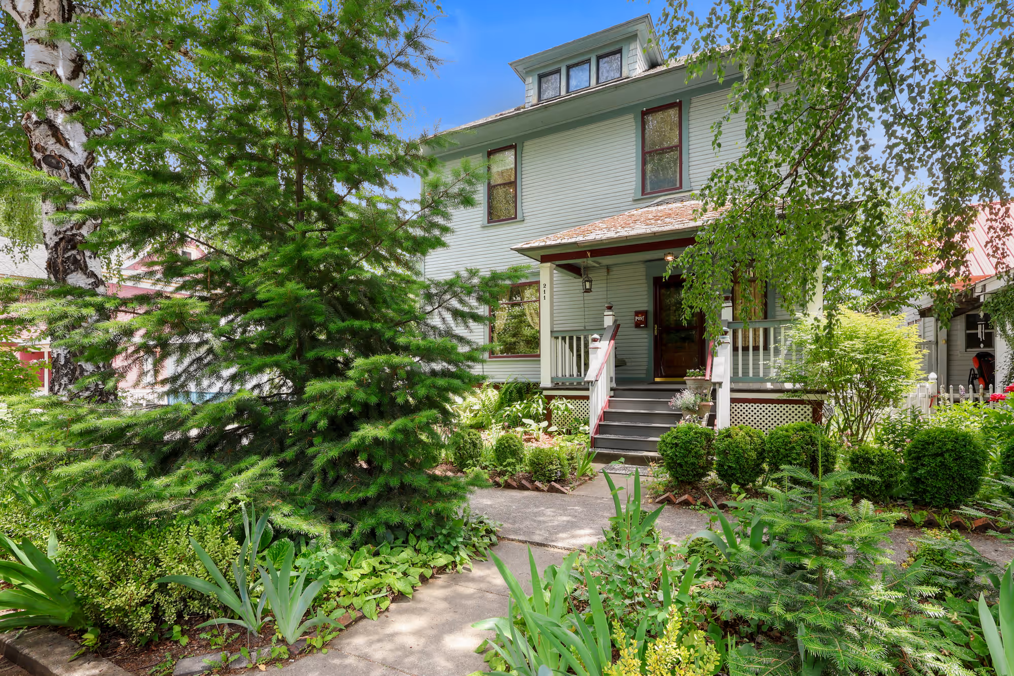 Craftsman-era home behind a lush landscaped front walk