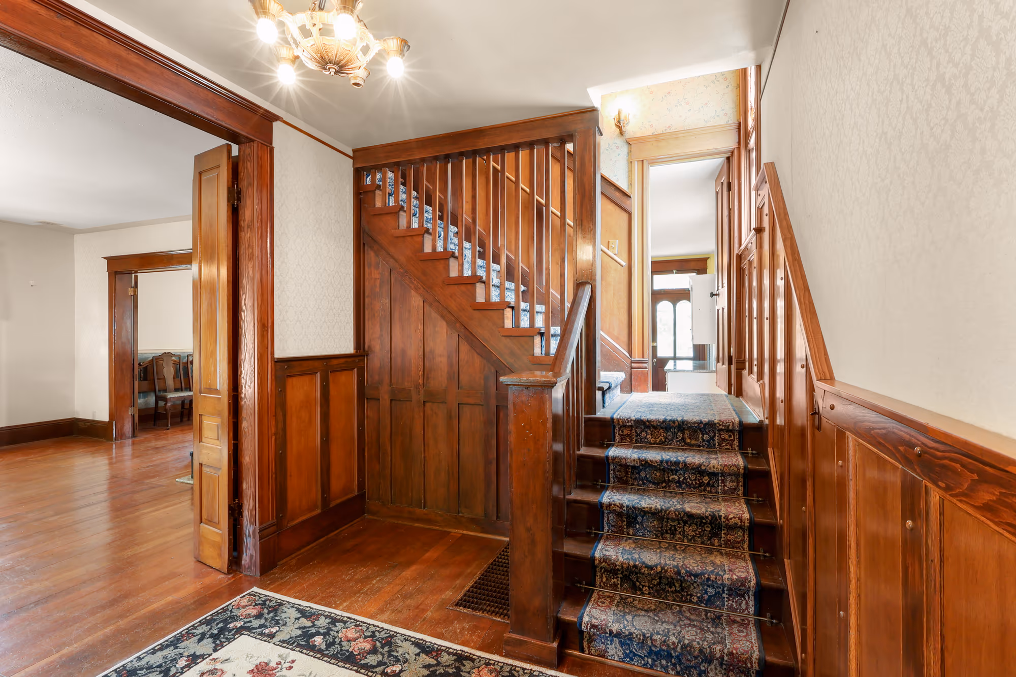 Original craftsman staircase with wood banister and paneling