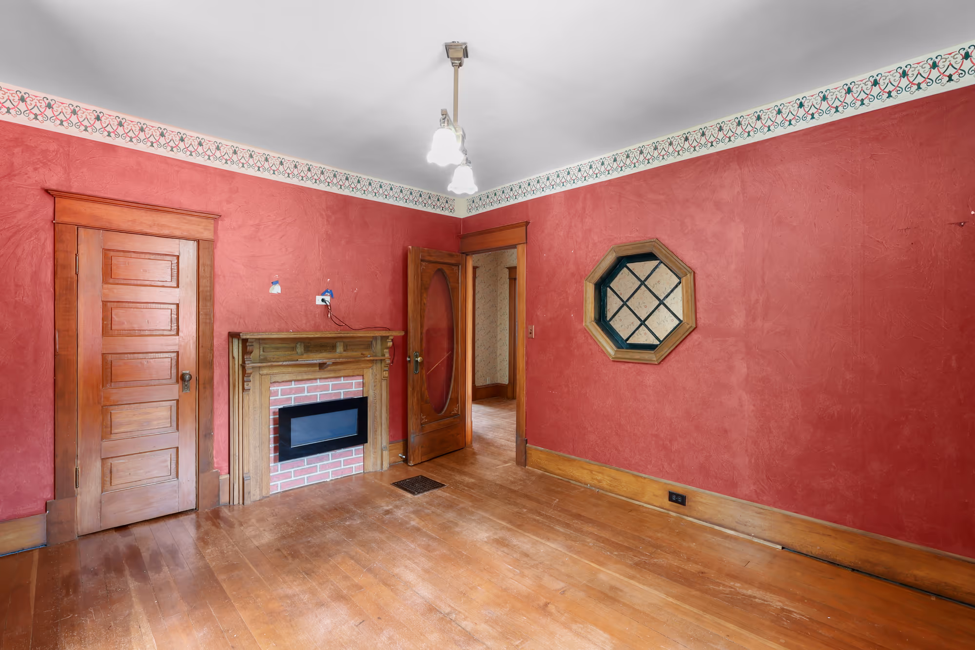 Sitting room with crimson walls, a fireplace, and an octagon window