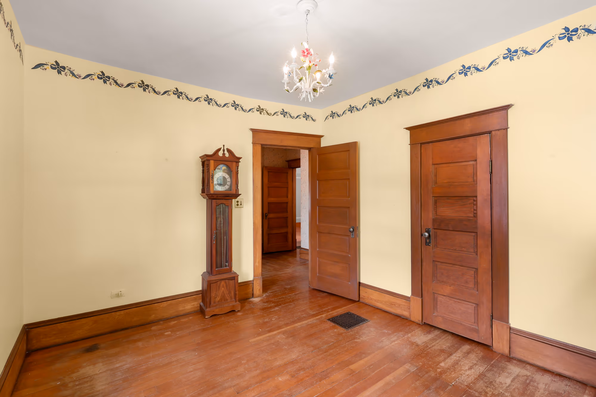 Bedroom with a hand-stenciled border and original wood doors