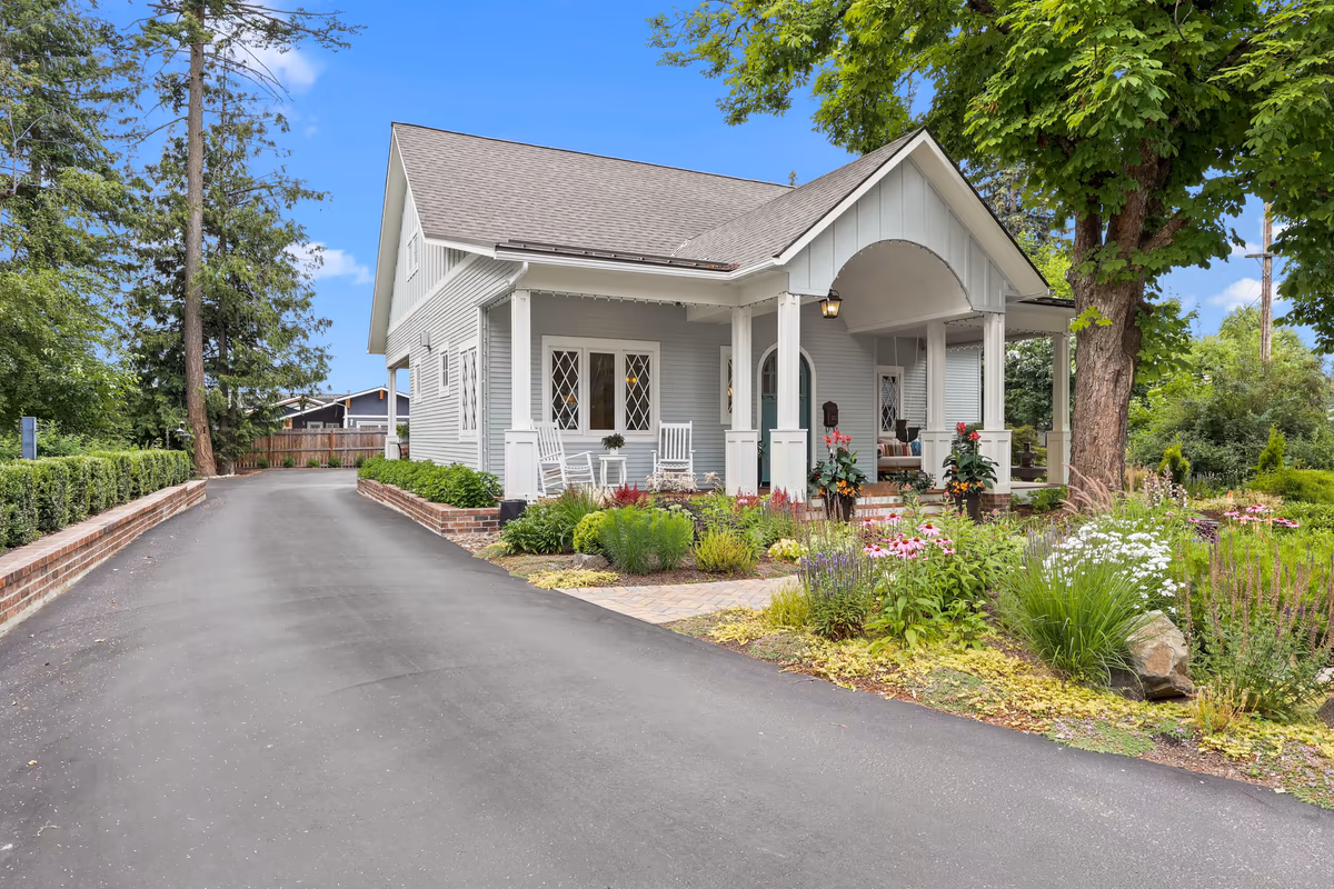 Angled view of the light-blue cottage and its driveway
