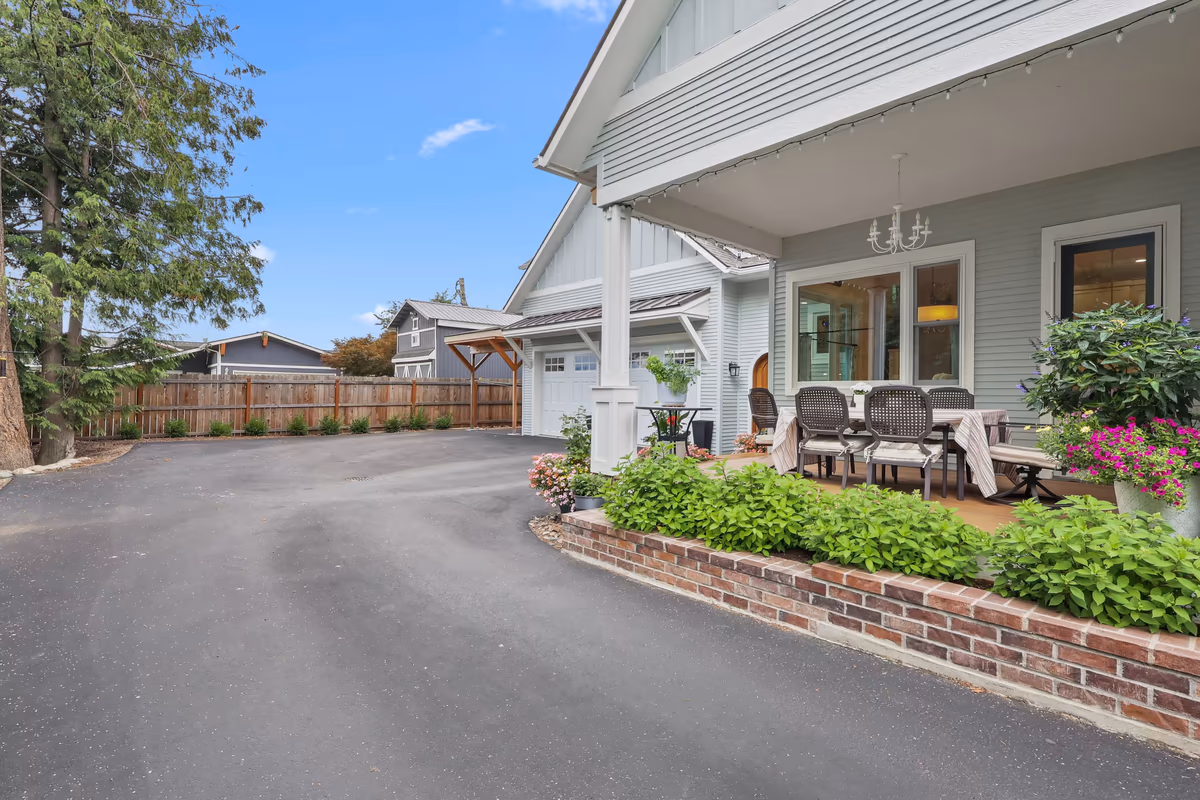 Side porch of the light-blue cottage beside the paved driveway