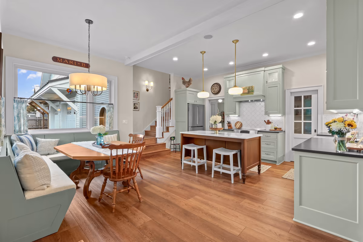 Connected breakfast nook, kitchen, and staircase with wood floors