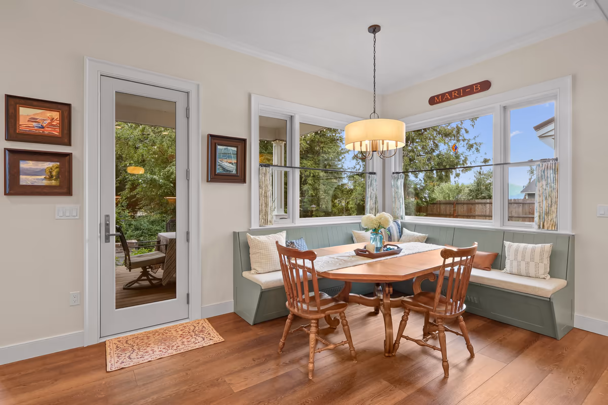 Sunlit breakfast nook with a built-in bench and round dining table