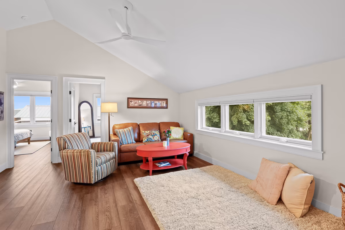 Upstairs lounge with a red coffee table and wide windows